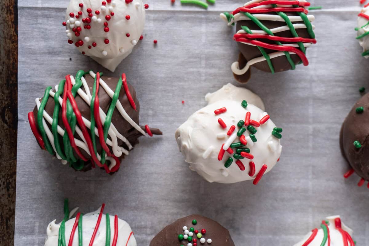 christmas oreo ball dipped and decorated on parchment paper