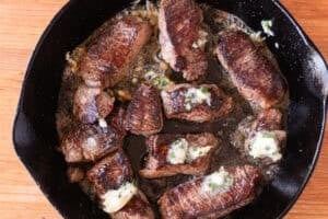 filet medallions in cast iron pan with butter on them