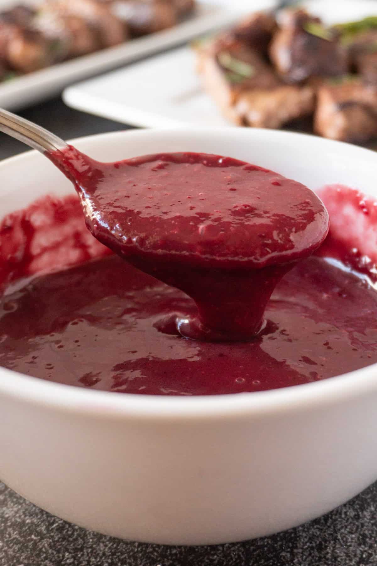 blackberry sauce spooned out of bowl.