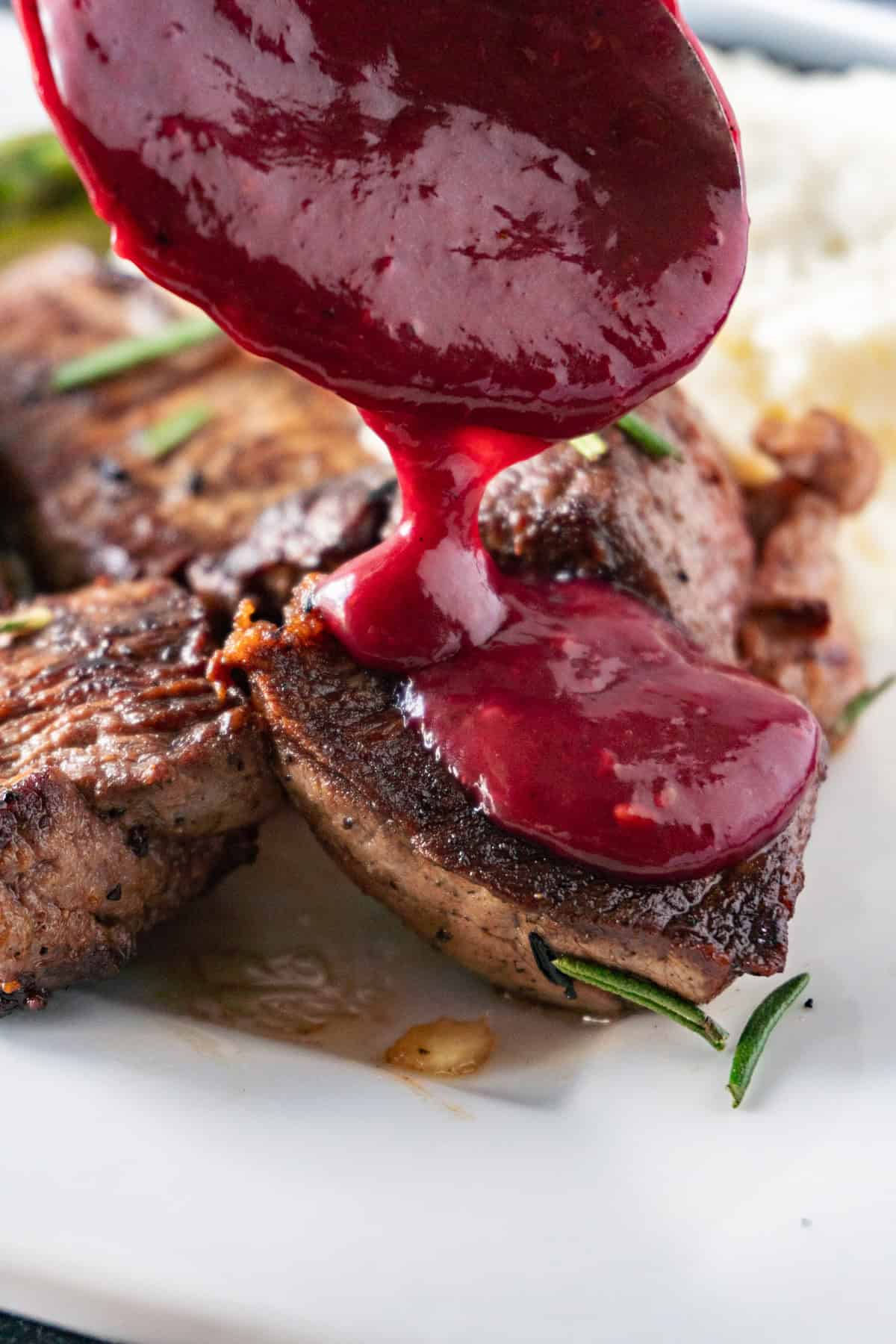 pouring blackberry sauce over filet medallions.
