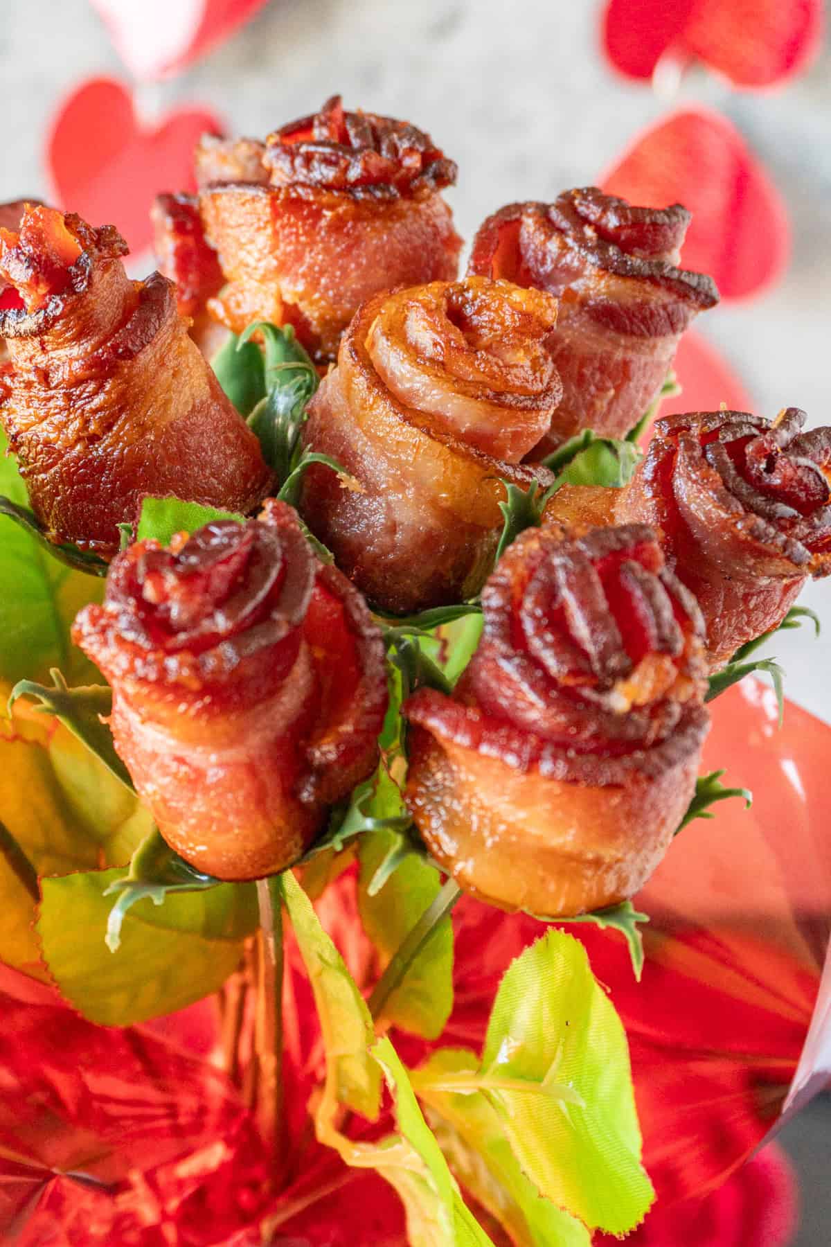 bacon roses in a bouquet wrapped in red cellophane.