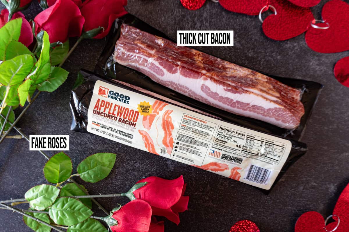 two packs of bacon and fake roses  on dark back ground.