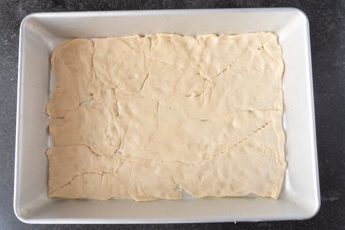 bottom crescent roll sheet pressed into baking dish.