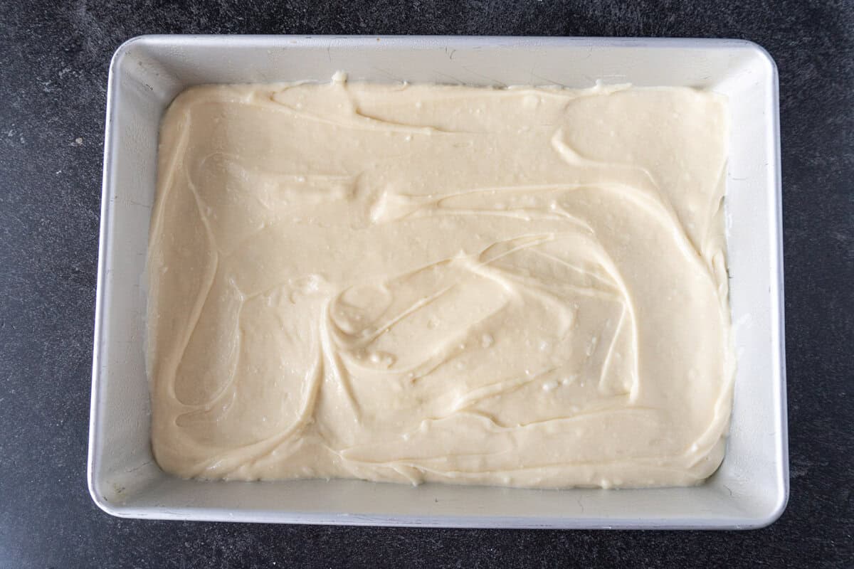 cheesecake filling spread out in baking dish.