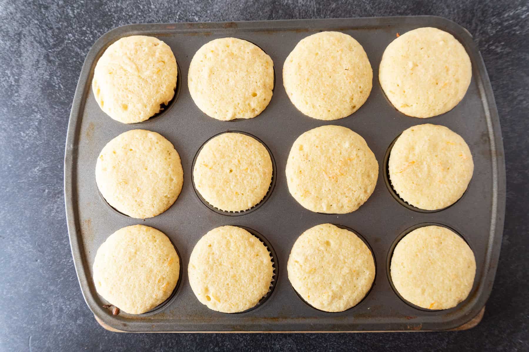 baked orange cupcakes in cupcake pan.