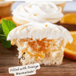 Orange Cupcake cut in half on a wooden cutting board showing orange filling, pinterest pin.