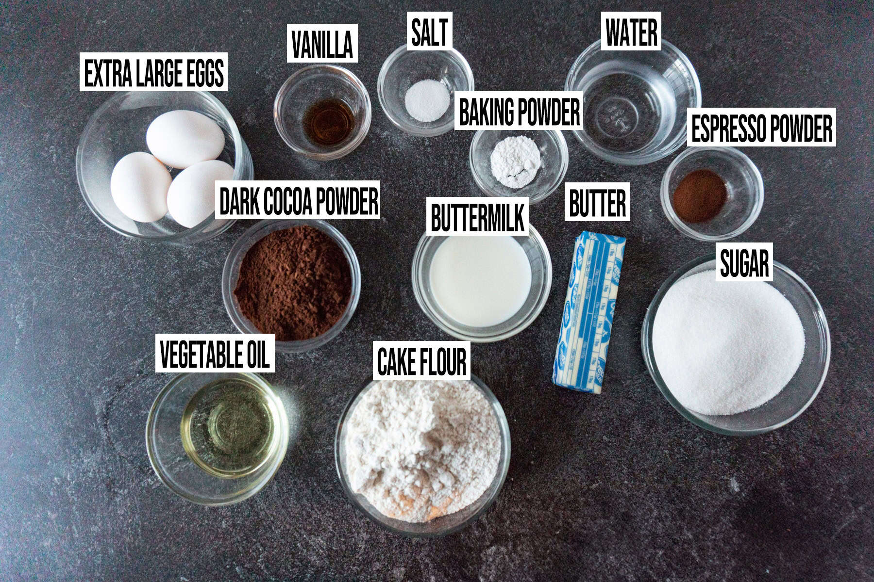 Halloween graveyard cake ingredients in individual bowls and labeled.