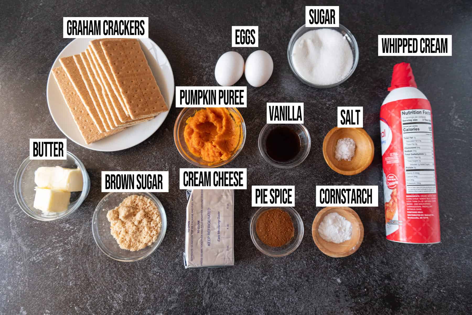 Mini Pumpkin Cheesecakes ingredients laid out and in individual bowls and labeled.