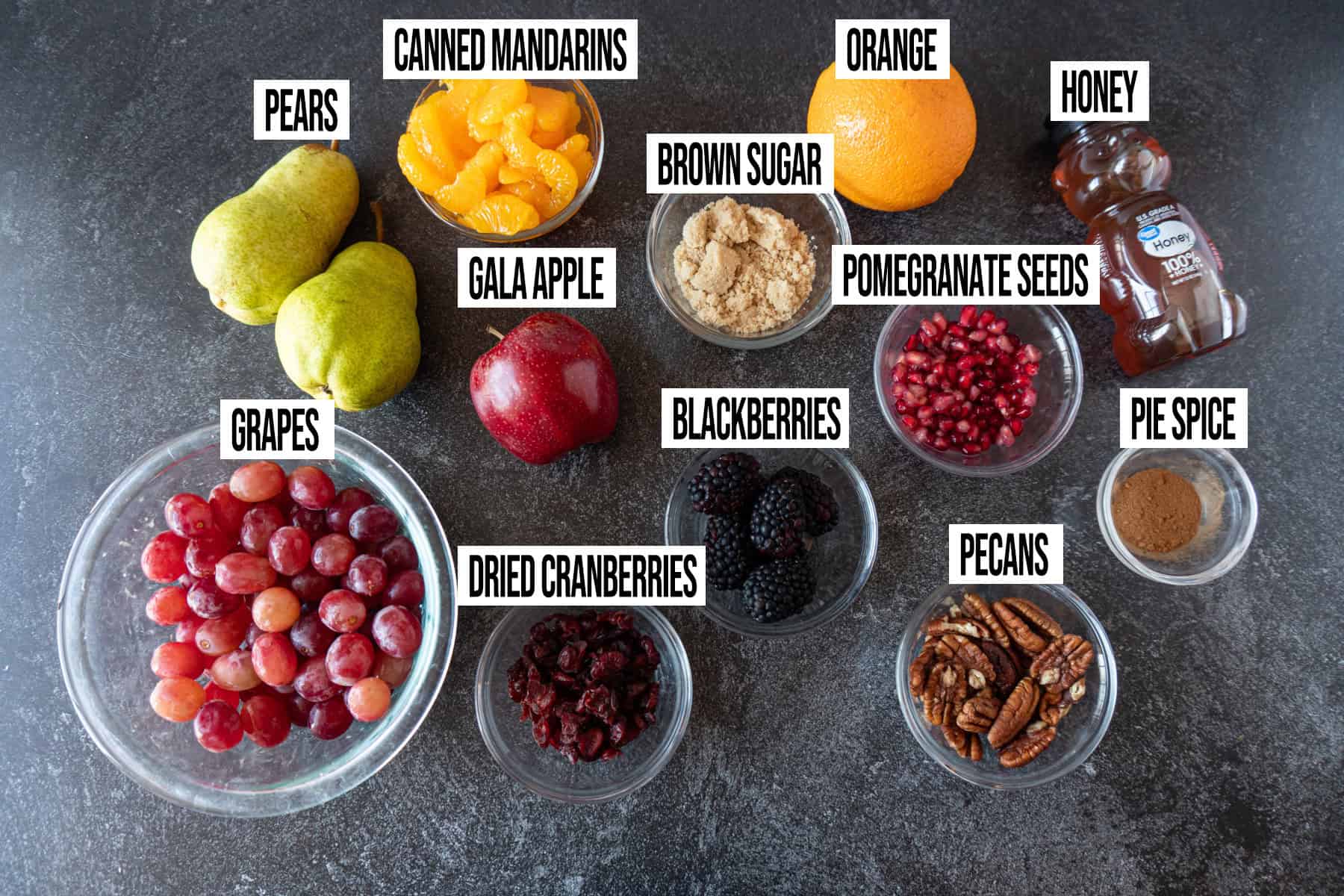 Thanksgiving Fruit Salad ingredients laid out and in individual bowls and labeled.